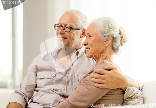 Image of happy senior couple sitting on sofa at home