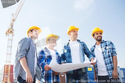 Image of group of builders with tablet pc and blueprint