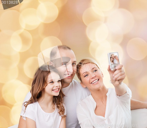 Image of happy family with camera at home