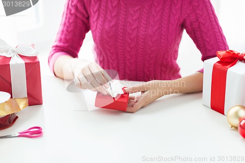 Image of close up of woman decorating christmas presents