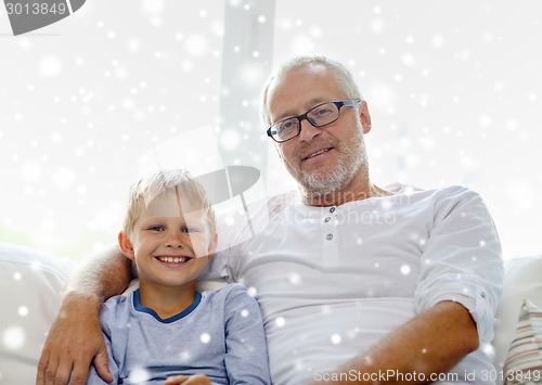 Image of smiling grandfather and grandson at home