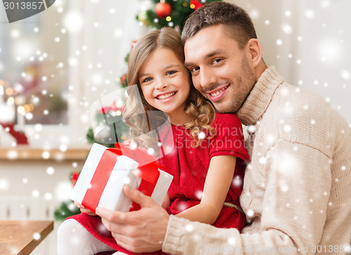 Image of smiling father and daughter holding gift box
