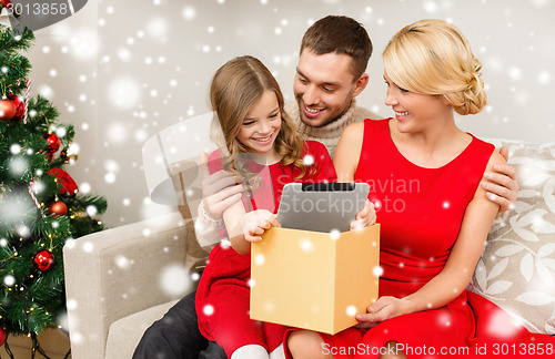 Image of smiling family taking tablet pc out from gift box