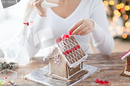 Image of close up of woman making gingerbread houses