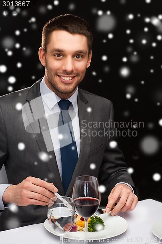 Image of smiling man with tablet pc eating main course