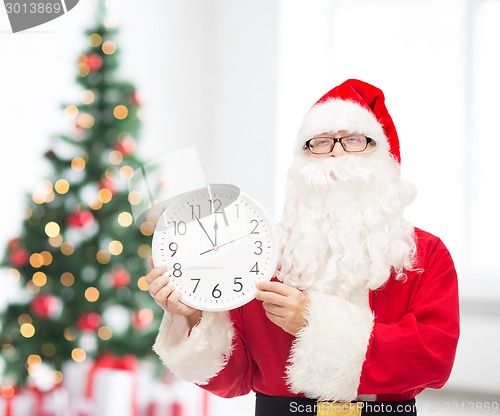 Image of man in costume of santa claus with clock