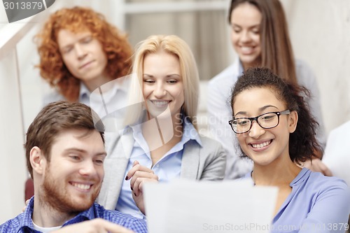 Image of team with papers and take away coffee on staircase