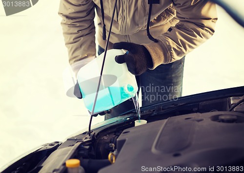 Image of closeup of man pouring antifreeze into water tank