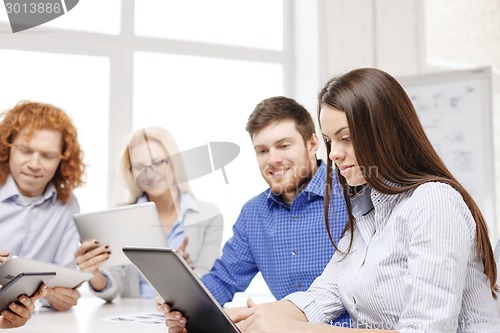 Image of smiling team with table pc and papers working