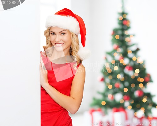 Image of smiling young woman in santa hat with white board