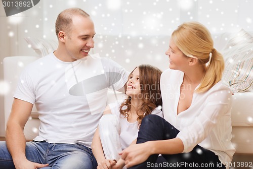 Image of smiling parents and little girl at home