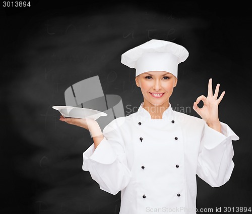 Image of female chef with empty plate showing ok sign