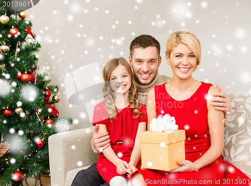 Image of smiling family holding gift box