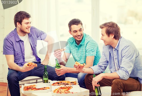 Image of smiling friends with beer and pizza hanging out