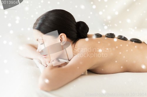 Image of woman in spa salon with hot stones