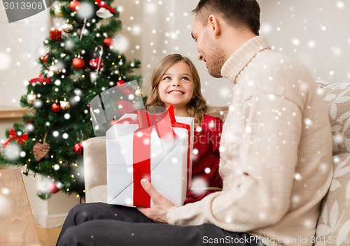 Image of smiling father and daughter holding gift box