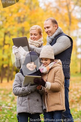 Image of happy family with tablet pc in autumn park