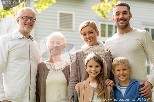 Image of happy family in front of house outdoors