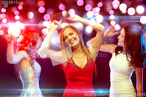 Image of three smiling women dancing in the club