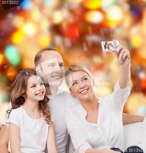 Image of happy family with camera at home