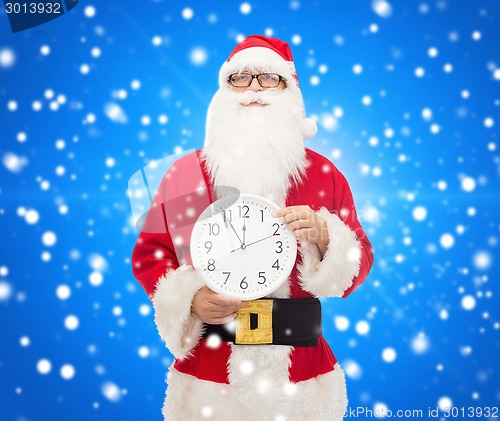 Image of man in costume of santa claus with clock