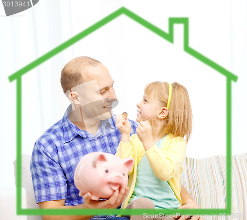Image of happy father and daughter with big piggy bank