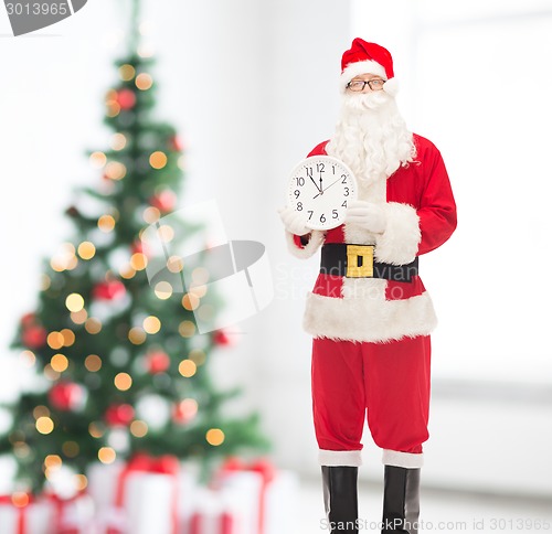 Image of man in costume of santa claus with clock