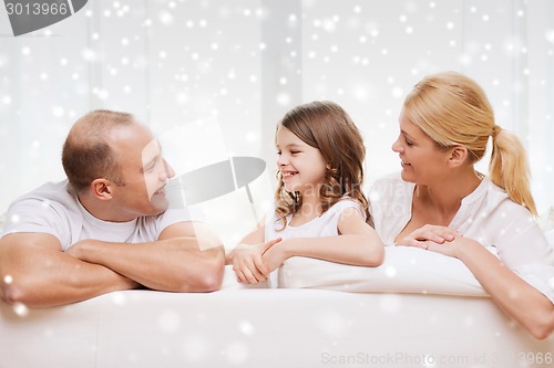 Image of smiling parents and little girl at home