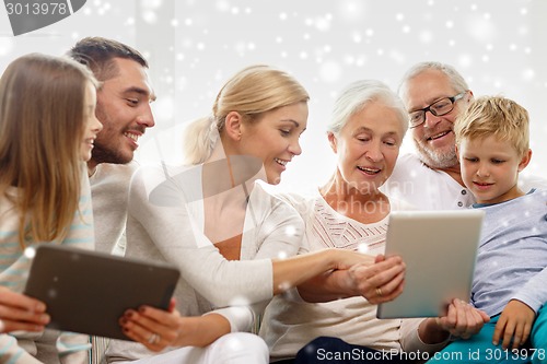 Image of smiling family with tablet pc computers at home