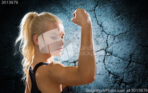 Image of sporty woman flexing and showing biceps from back