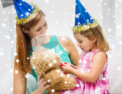 Image of mother and daughter in party hats with toy