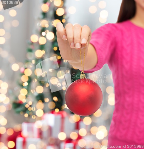 Image of close up of woman in sweater with christmas ball