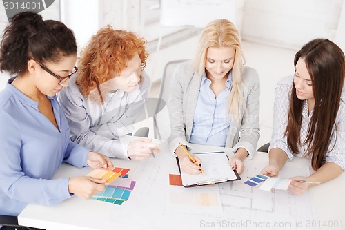 Image of team with color samples and blueprint at office