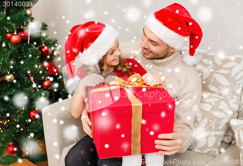 Image of smiling father and daughter holding gift box