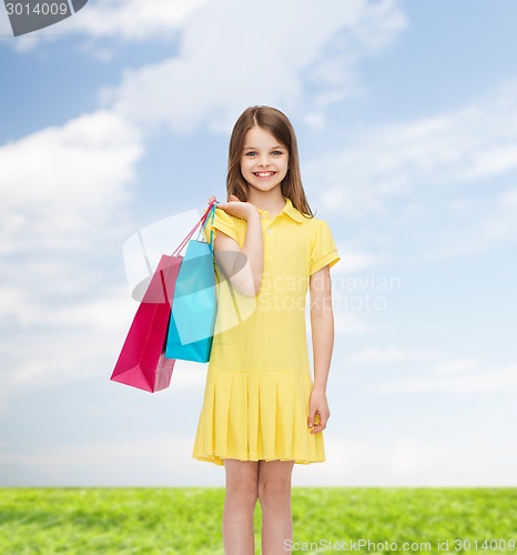Image of smiling little girl in dress with shopping bags