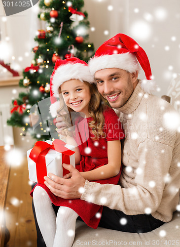 Image of smiling father and daughter holding gift box