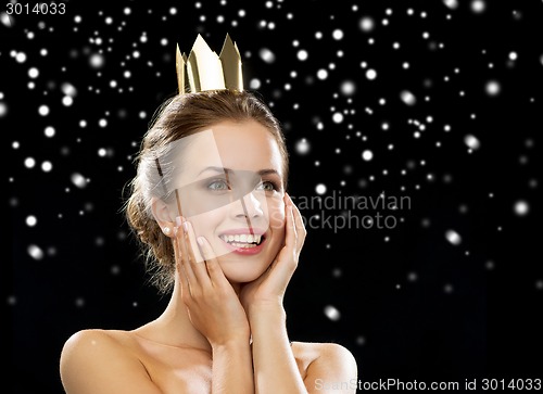 Image of smiling woman in evening dress wearing crown