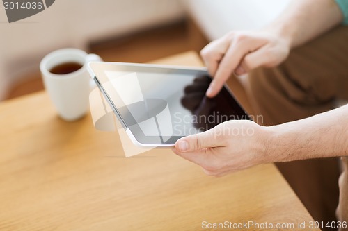 Image of close up of man with laptop and cup at home