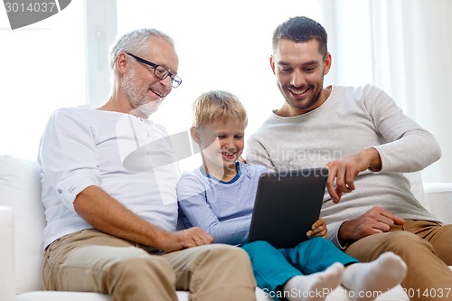 Image of smiling family with tablet pc at home