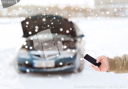 Image of closeup of man with broken car and smartphone