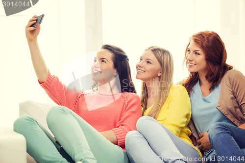 Image of teenage girls taking selfie with smartphone