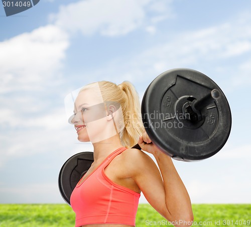 Image of smiling sporty woman exercising with barbell