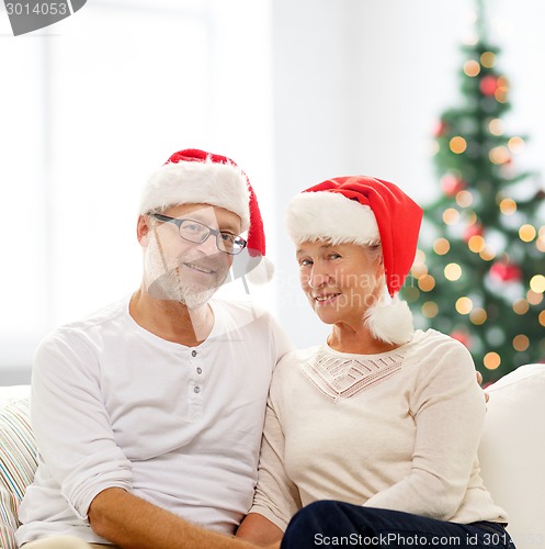 Image of happy senior couple in santa helper hats