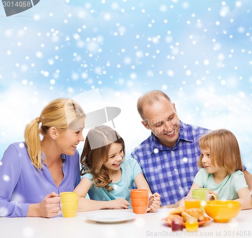 Image of happy family with two kids having breakfast