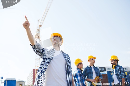 Image of group of smiling builders in hardhats outdoors