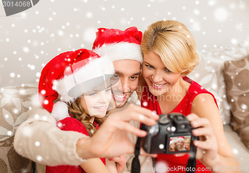 Image of happy family with digital camera taking photo