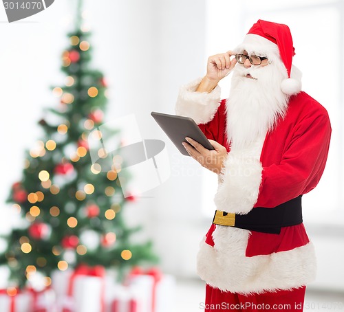 Image of man in costume of santa claus with tablet pc