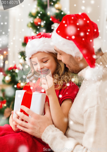 Image of smiling father and daughter holding gift box