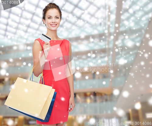 Image of smiling woman with shopping bags and plastic card