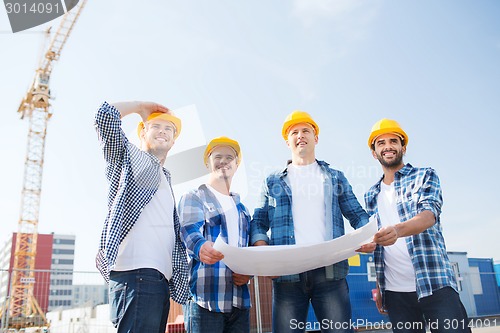 Image of group of builders with tablet pc and blueprint